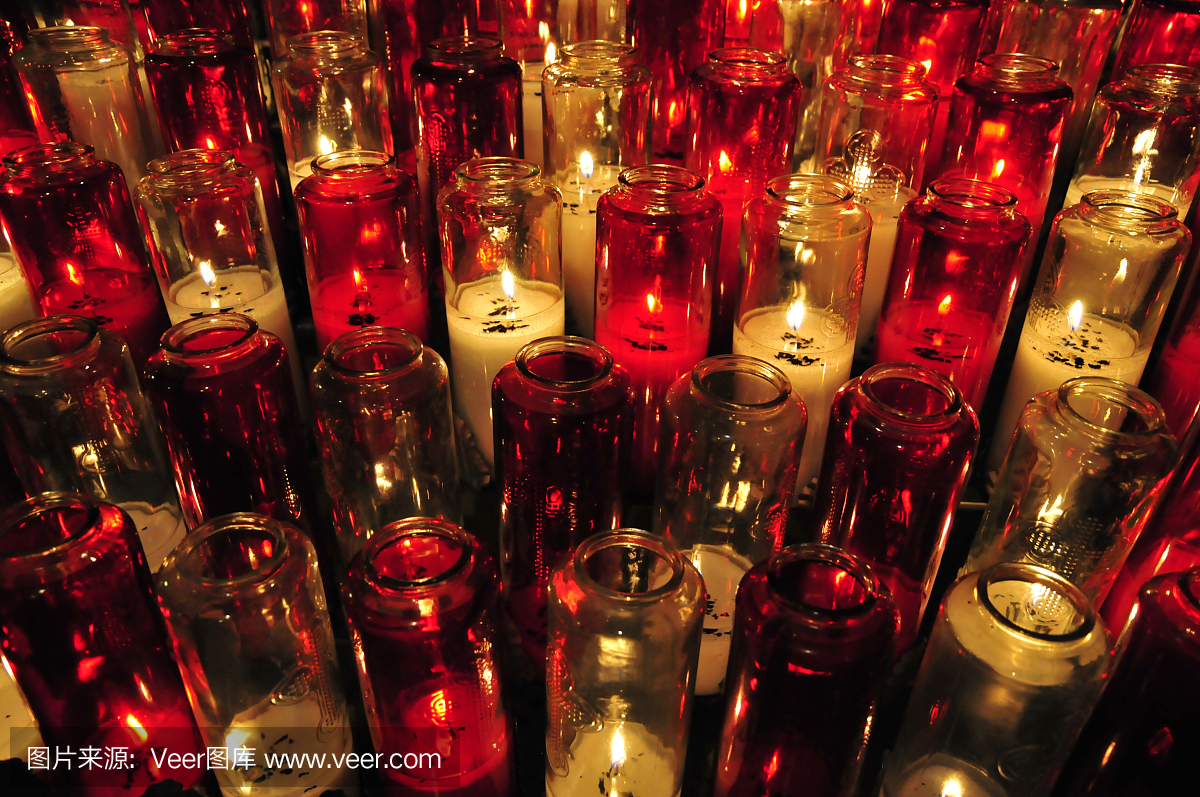 燃烧的蜡烛在透明和红色的小瓶。高角度视图